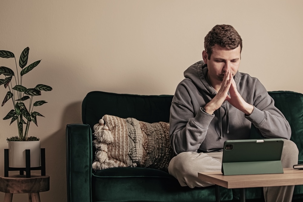 Man sitting on the couch during telehealth on demand counseling