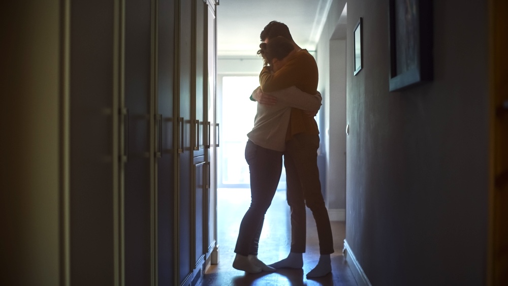 Couple struggling with anxiety in their relationship hugging