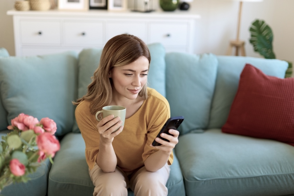 Young woman sitting on a green sofa while looking at inspiring positive mental health quotes